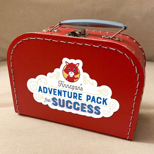 Red vintage-style suitcase with Finnegan's Adventure Pack for Success label and cartoon fox mascot on white cloud design