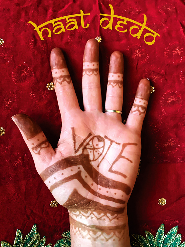 Henna-decorated hand with intricate mehndi patterns on red fabric background with haat dedo text overlay