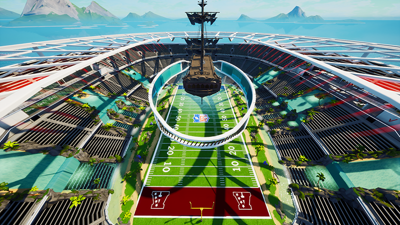 Futuristic football stadium on aircraft carrier with green field, red end zones, and ocean mountain backdrop