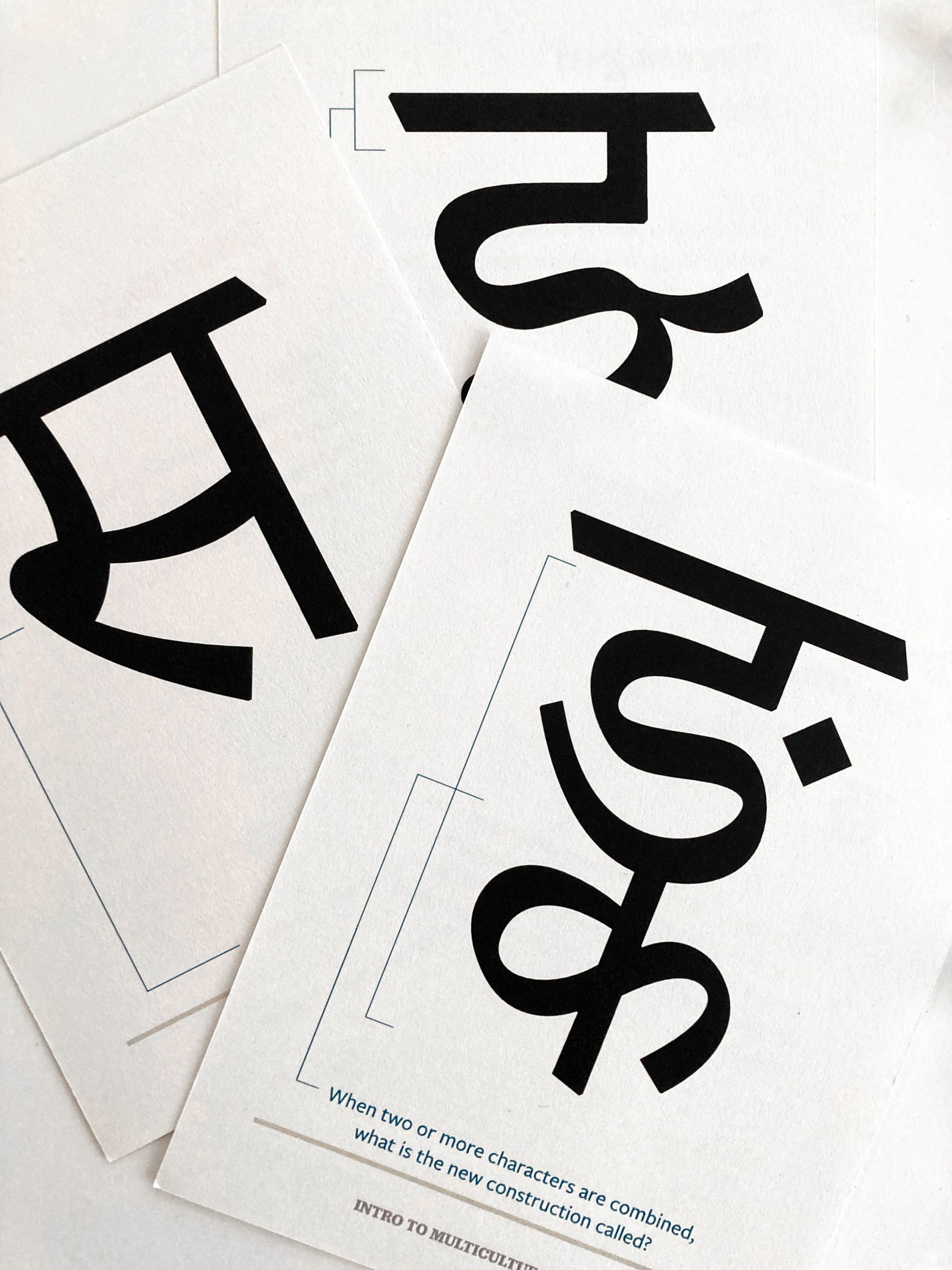 IMG_9044 Typography design cards showing large black letters on white paper with construction guidelines and educational text below.