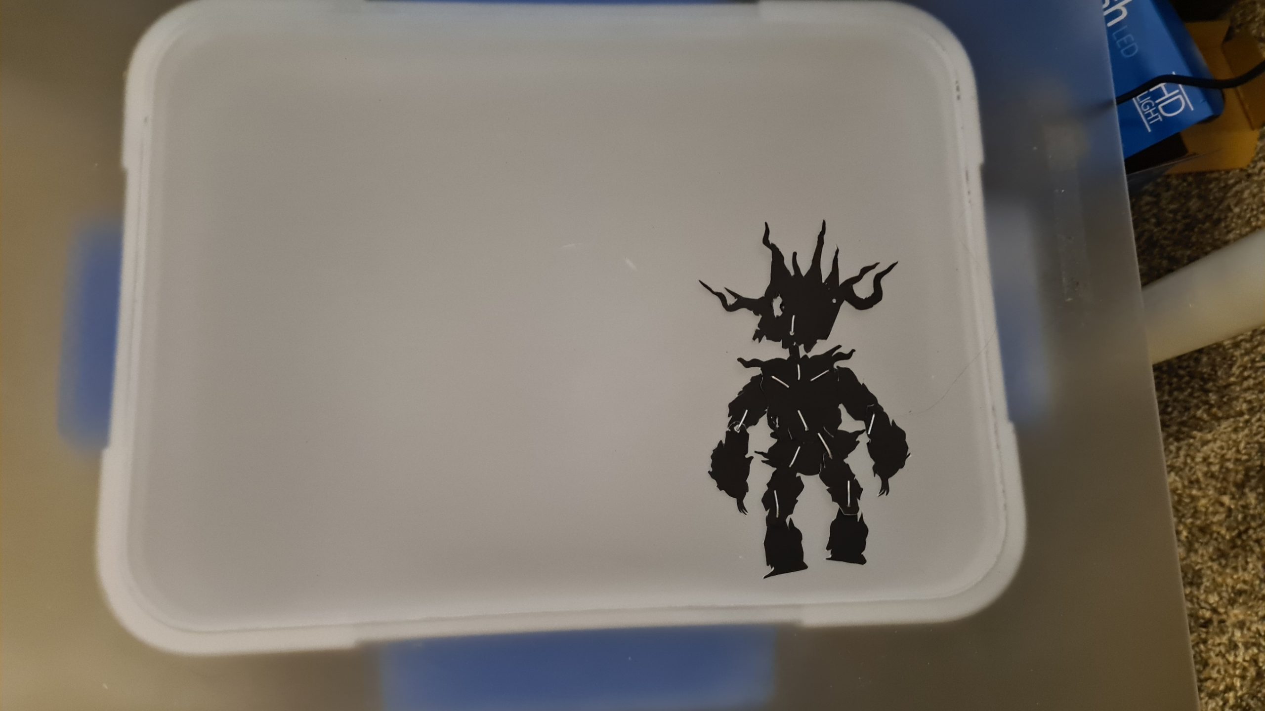 002-PaperPuppetTest White storage container with black silhouette decal of armored fantasy warrior character with spikes and horns