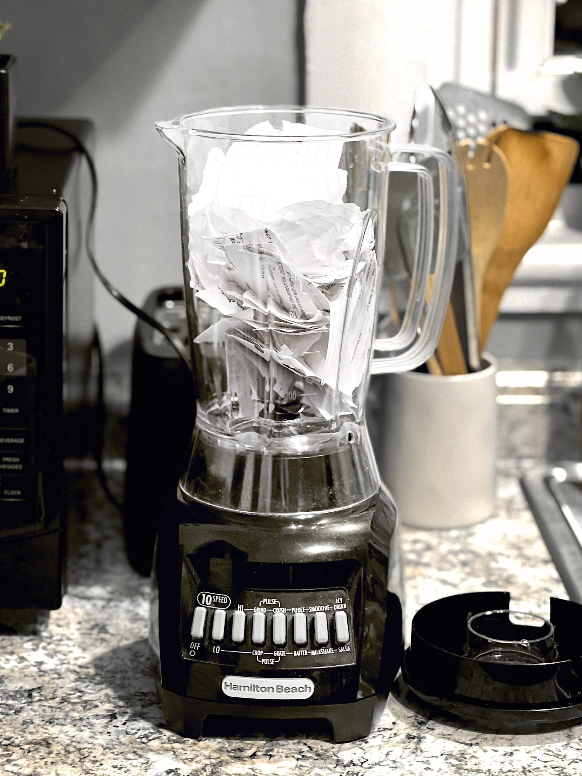 02 Hamilton Beach blender with glass pitcher filled with ice cubes on granite kitchen counter next to microwave