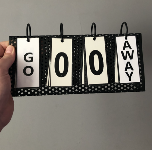 Noun - 3 Hand holding black polka dot flip chart displaying GO 0 0 AWAY message on white cards with ring binding