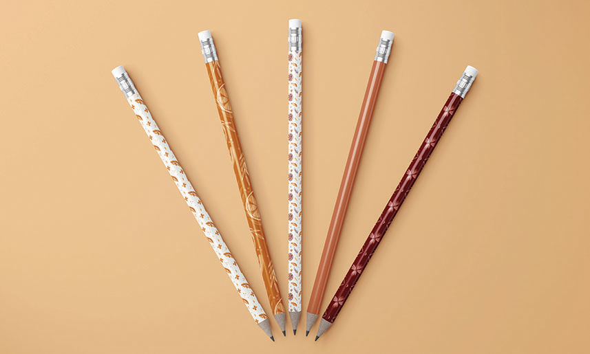 11_GarnetPearl Five decorative pencils with autumn-themed patterns in orange, white, and burgundy colors fanned out on beige background