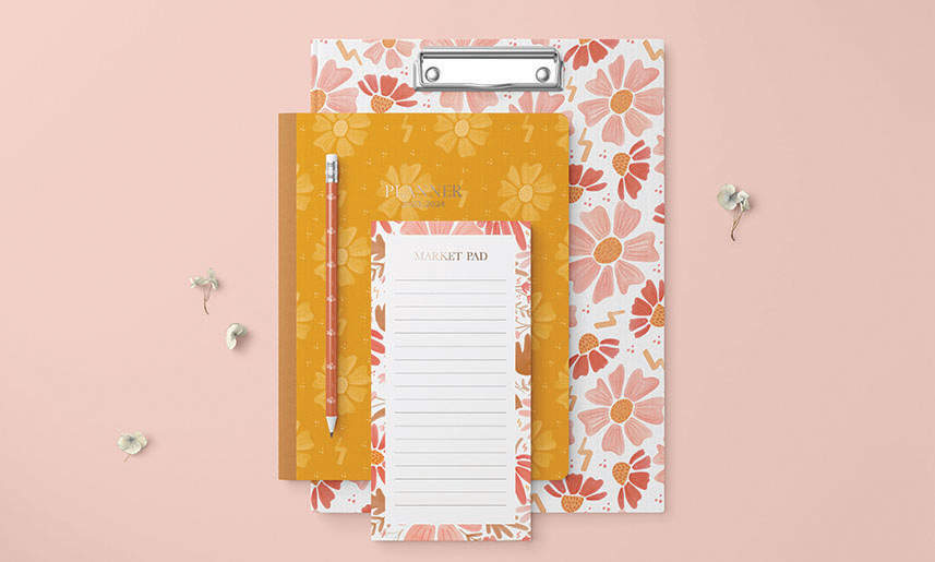1_GarnetPearl Floral clipboard with orange notebook, pencil and lined market pad notepad on pink background - stationery flat lay