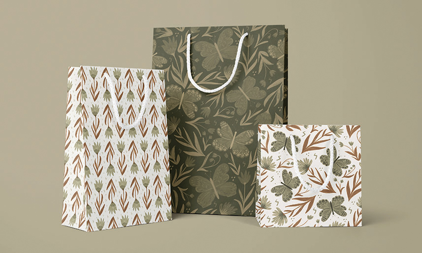 6_GarnetPearl Three decorative gift bags with botanical leaf patterns in green, brown and white earth tones on neutral background.